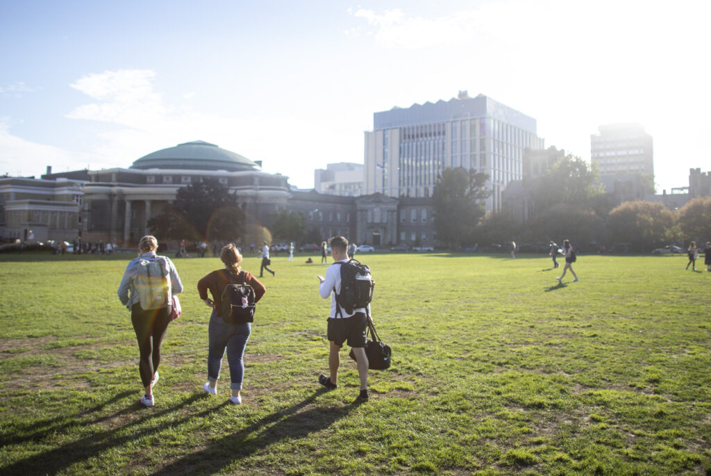 Three students walking across Front Campus.